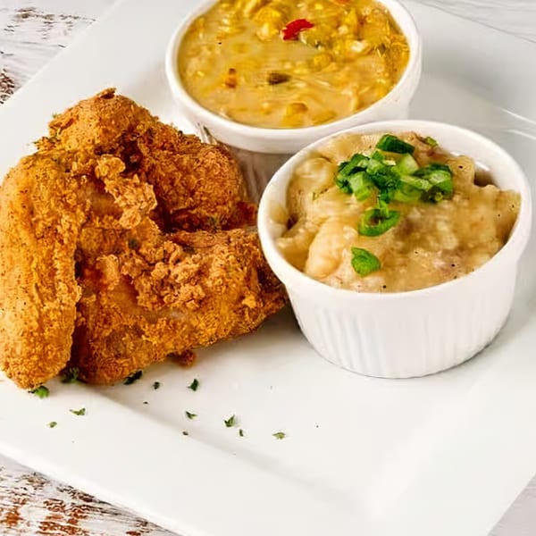 Soul Vibez fried chicken with two sides: mac and cheese topped with green onions, and creamed corn.